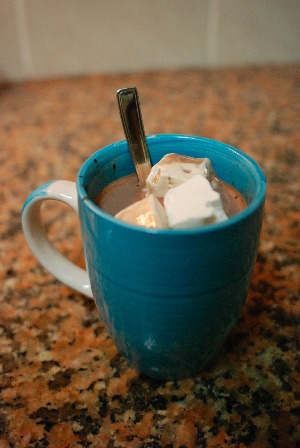 Tassa de llet amb cacau calenta i tres cubs de marshmallow